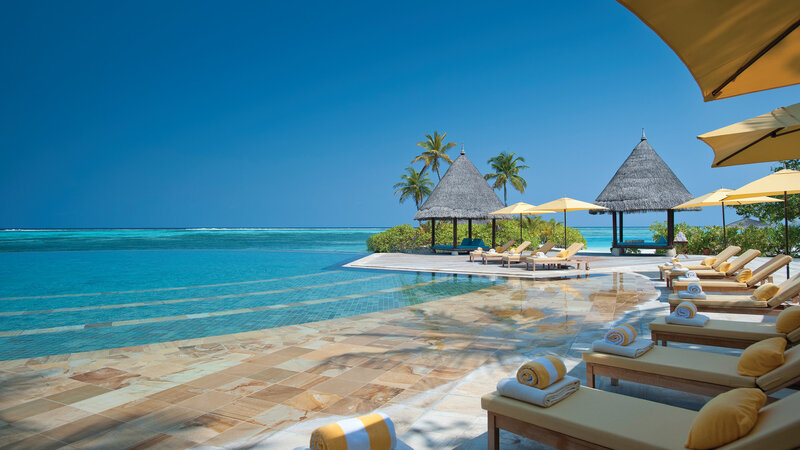 Infinity Pool at Resort — Blue, Serene, Afternoon, Photograph, Palm Trees, Thatched Huts