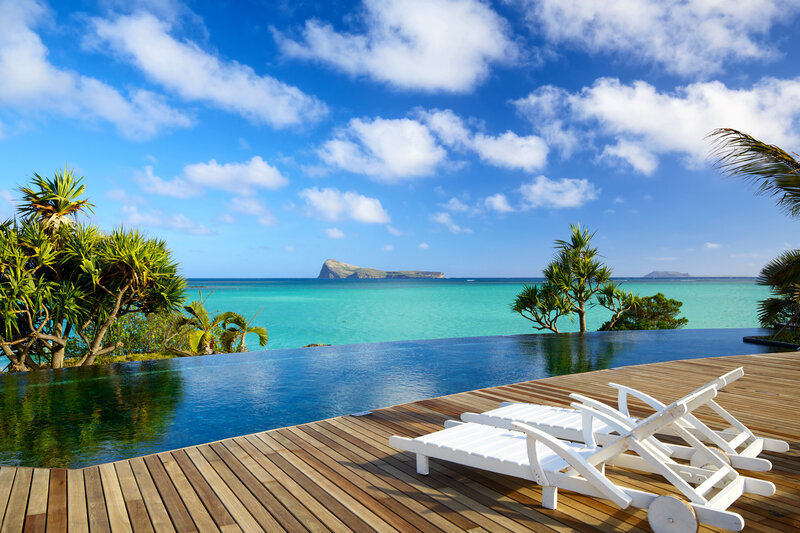 Infinity Pool Overlooking Ocean — Blue, Serene, Afternoon, Photograph, Lounge Chairs, Palm Trees