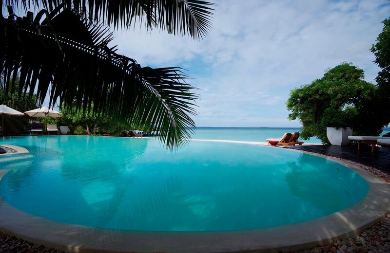 Infinity Pool Overlooking Ocean — Blue, Serene, Afternoon, Photograph, Palm Tree, Lounge Chairs, Umbrellas
