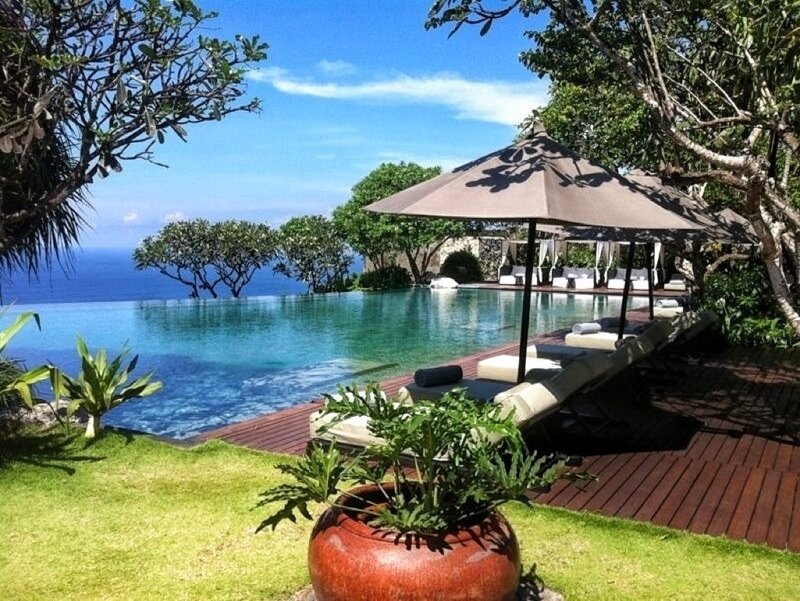 Infinity Pool Overlooking Ocean — Blue, Serene, Afternoon, Photograph, Umbrella, Lounge Chairs