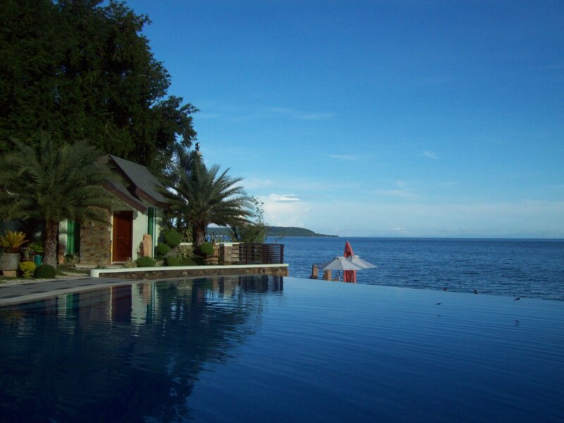 Infinity Pool Overlooking Ocean — Blue, Serene, Afternoon, Photograph, Umbrella