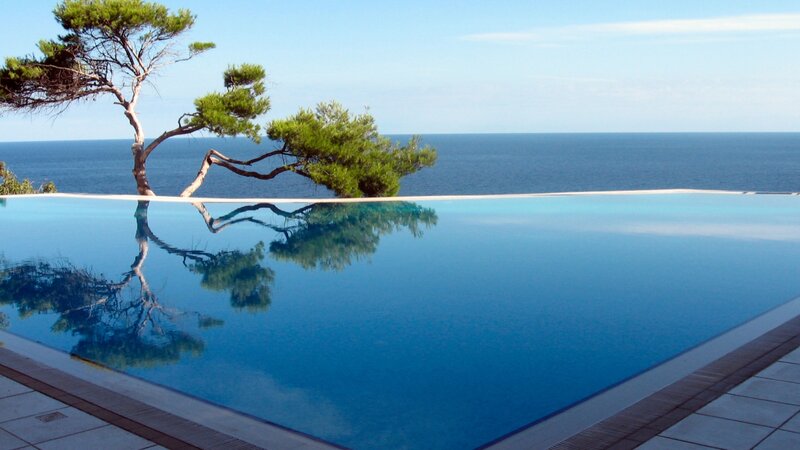 Infinity Pool Overlooking Sea — Blue, Serene, Afternoon, Photograph, Tree, Ocean, Sky, Tiles