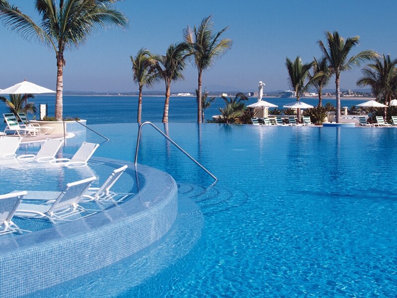 Infinity Pool with Ocean View — Blue, Serene, Afternoon, Photograph, Palm Trees, Lounge Chairs, Umbrellas, White