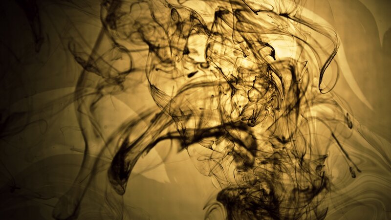 Ink swirling in golden liquid