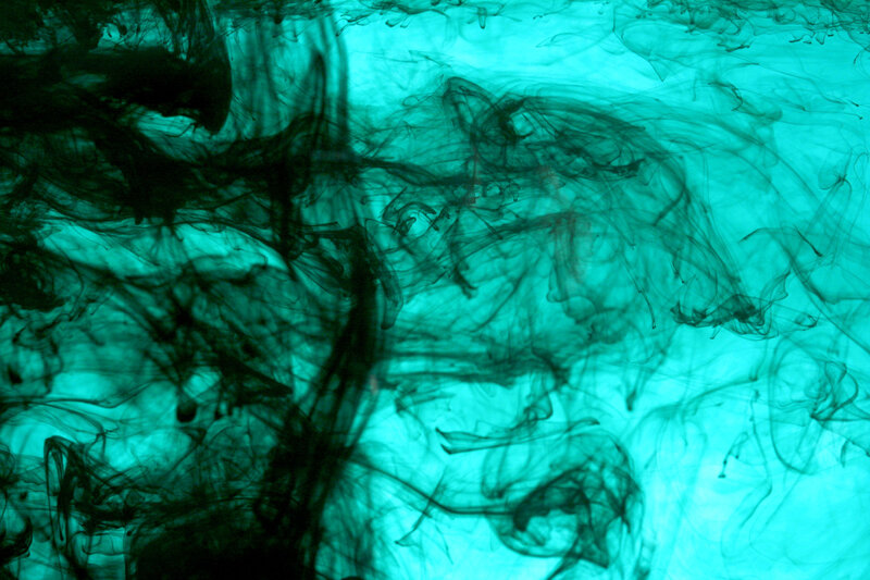 Ink swirling in turquoise water