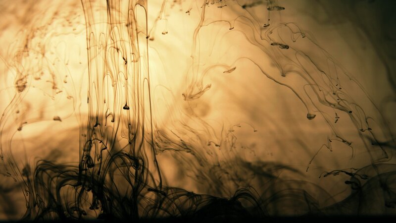 Ink swirling in warm light