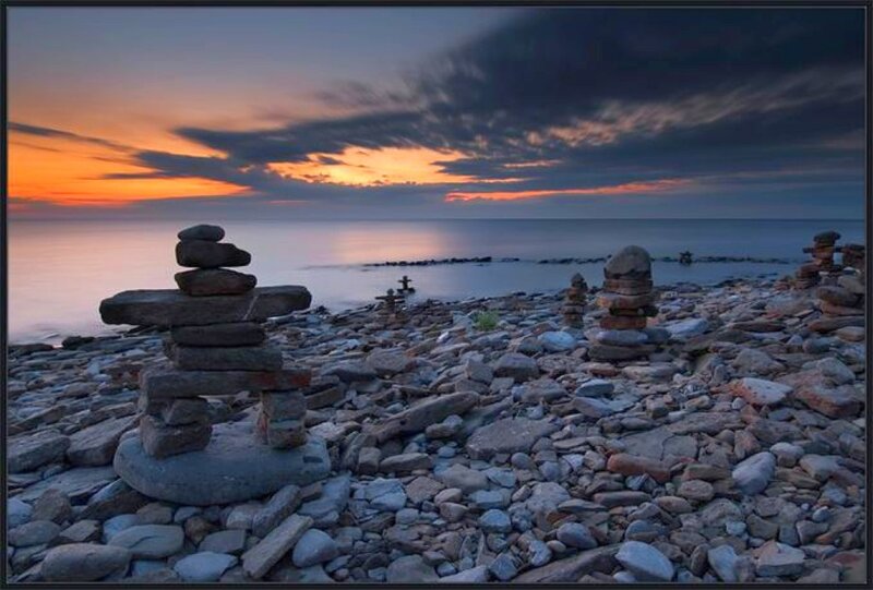 Inukshuk on a rocky beach at sunset