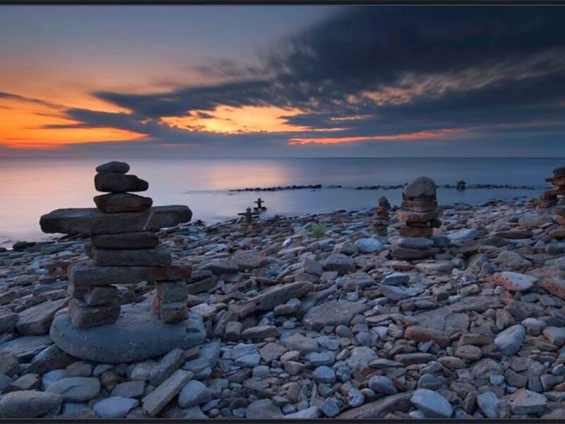 Inukshuk on a rocky beach at sunset
