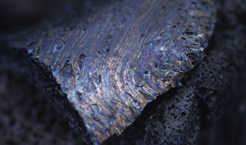 Iridescent volcanic rock surface