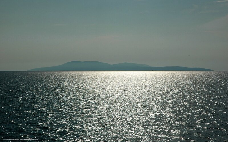 Island at sea with sun reflection