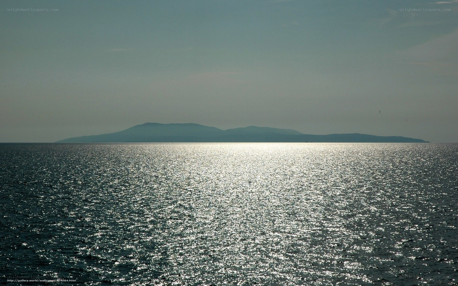 Island at sea with sun reflection