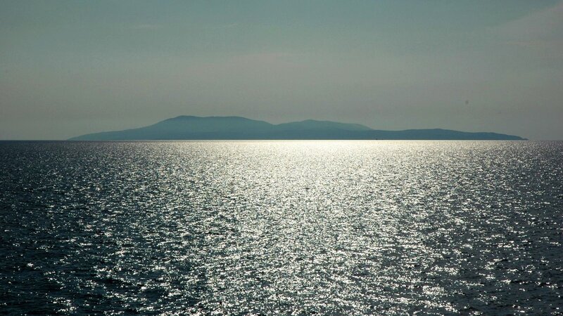 Island at sea with sunlit water
