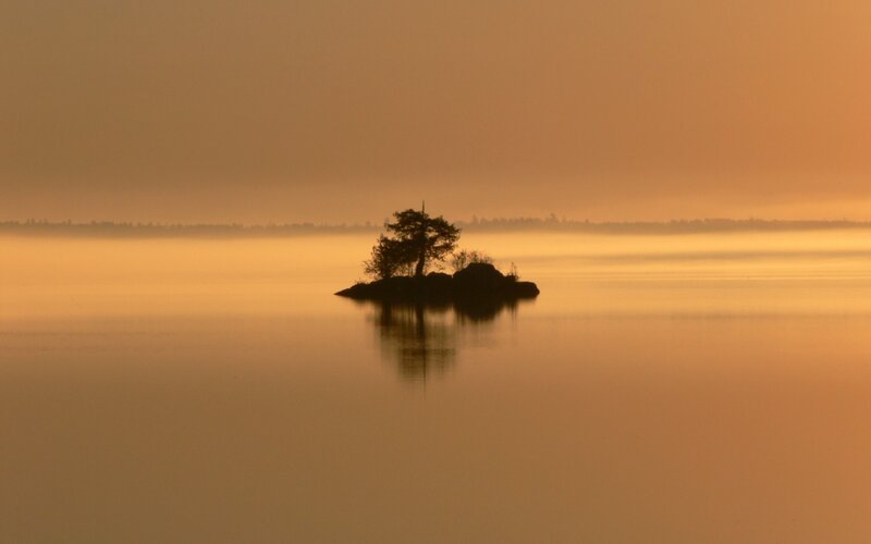 Island at sunrise on calm lake