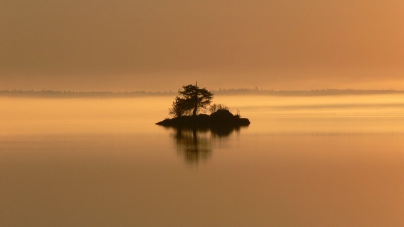 Island at sunrise on calm lake