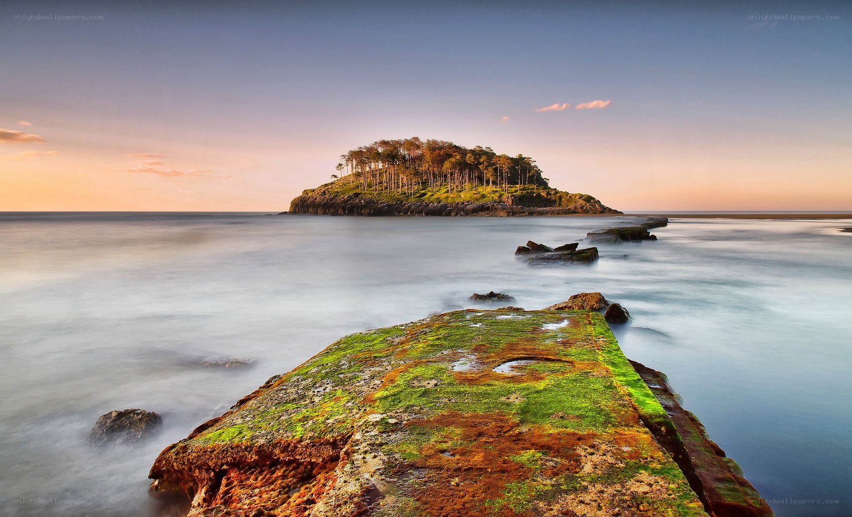 Island at sunset with mossy rocks