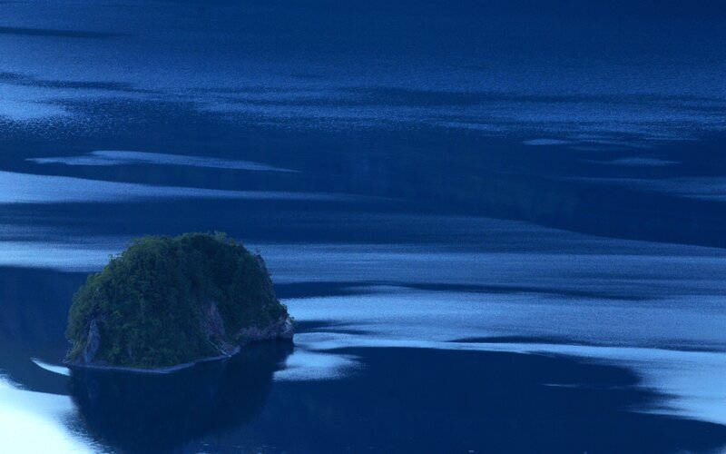 Island in a blue lake at dusk