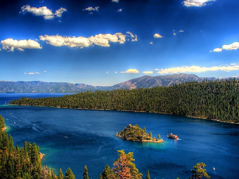Island in a blue lake with mountains