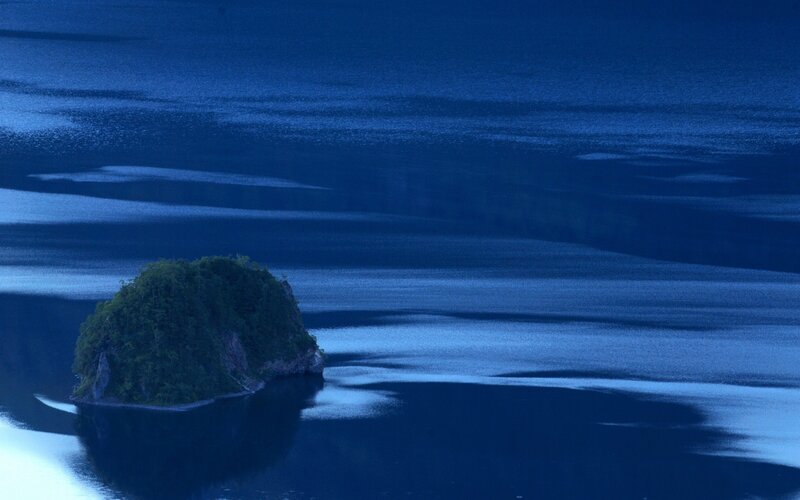 Island in a blue sea at dusk