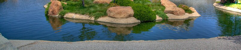 Island in a pond with rocks and shrubs