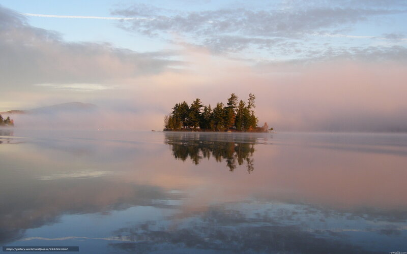 Island in misty lake at dawn