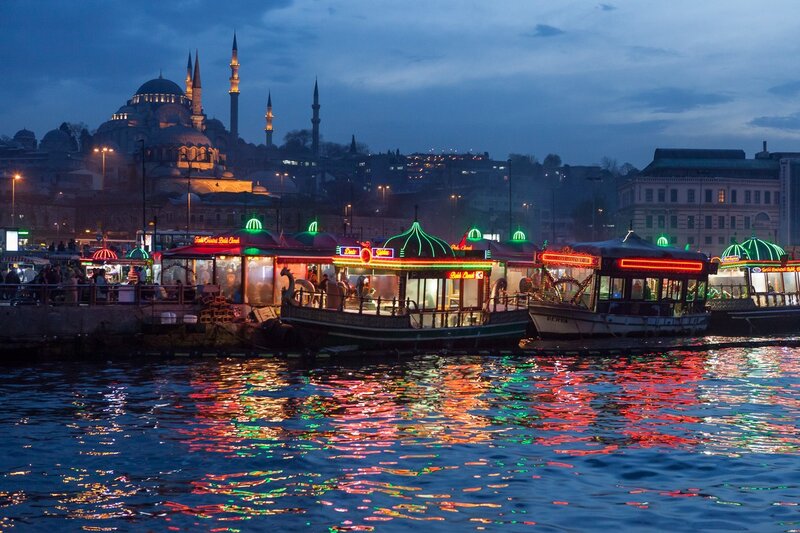 Istanbul at dusk with illuminated boats
