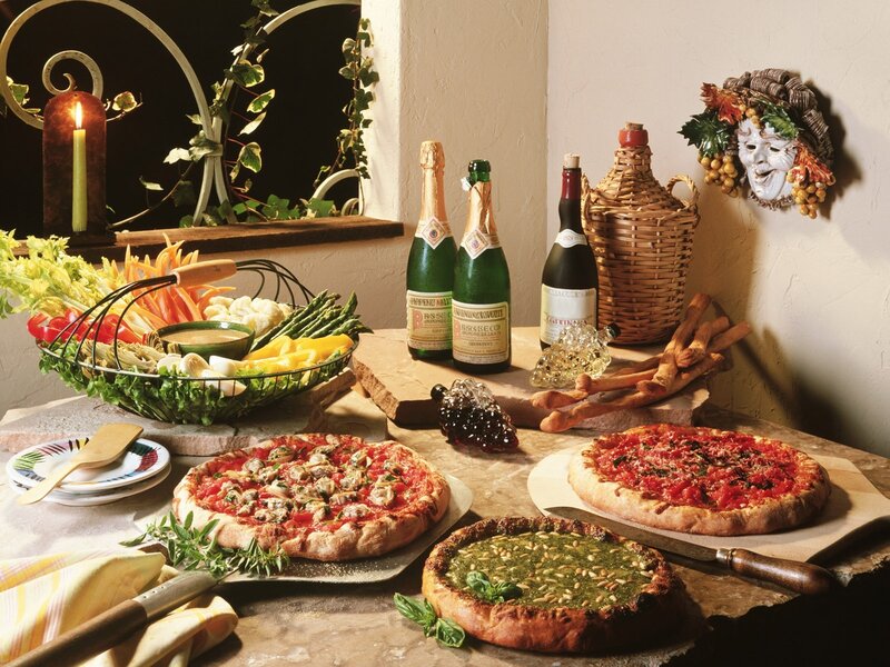 Italian food spread with pizzas and wine