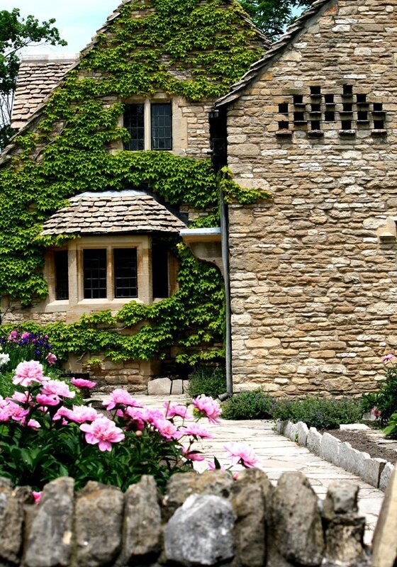 ivied stone cottage with pink flowers