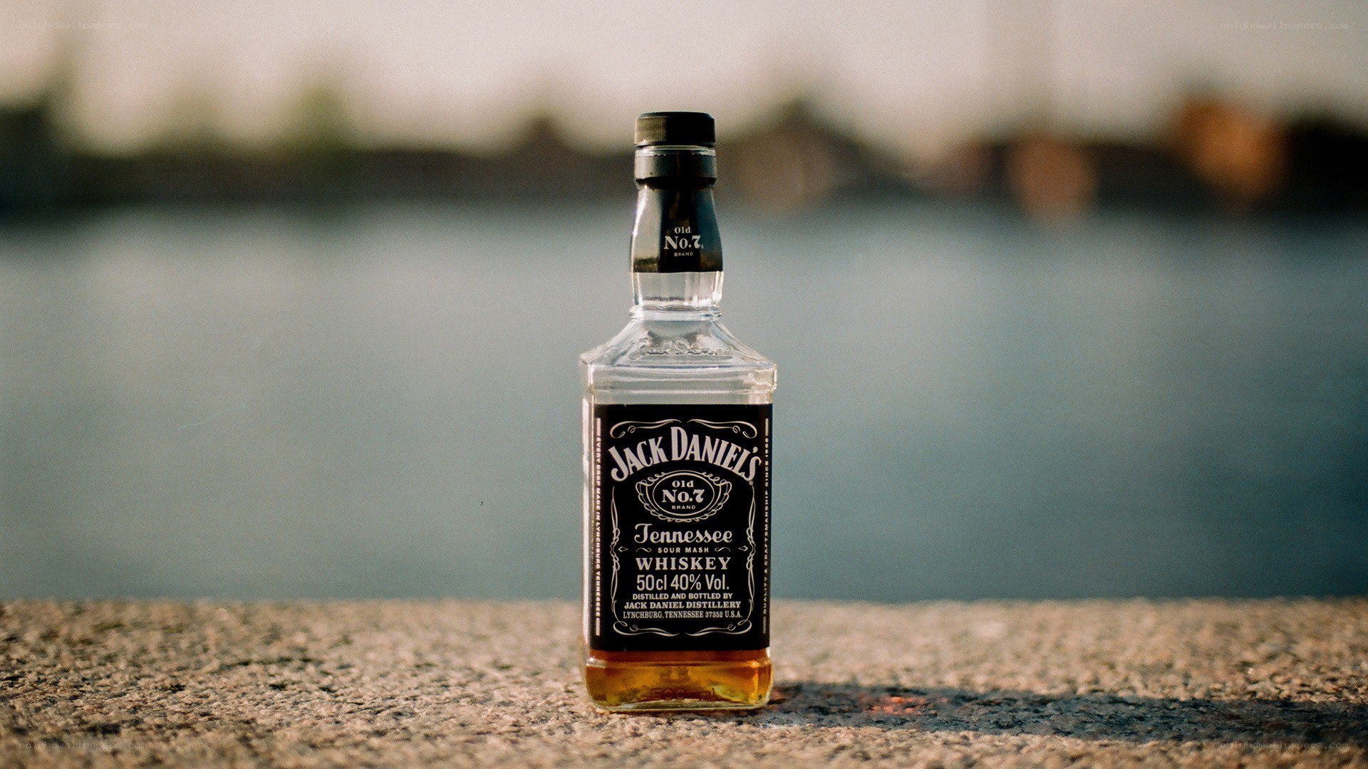 Jack Daniel's bottle by water