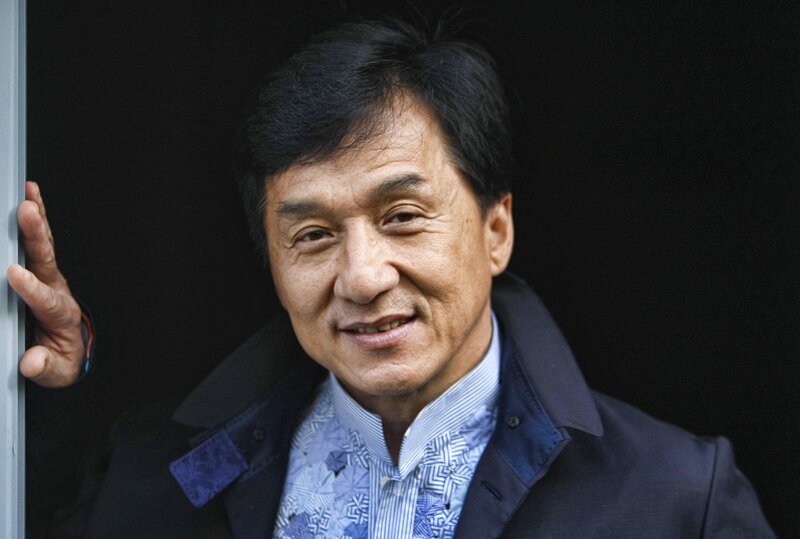 Jackie Chan smiling in a suit