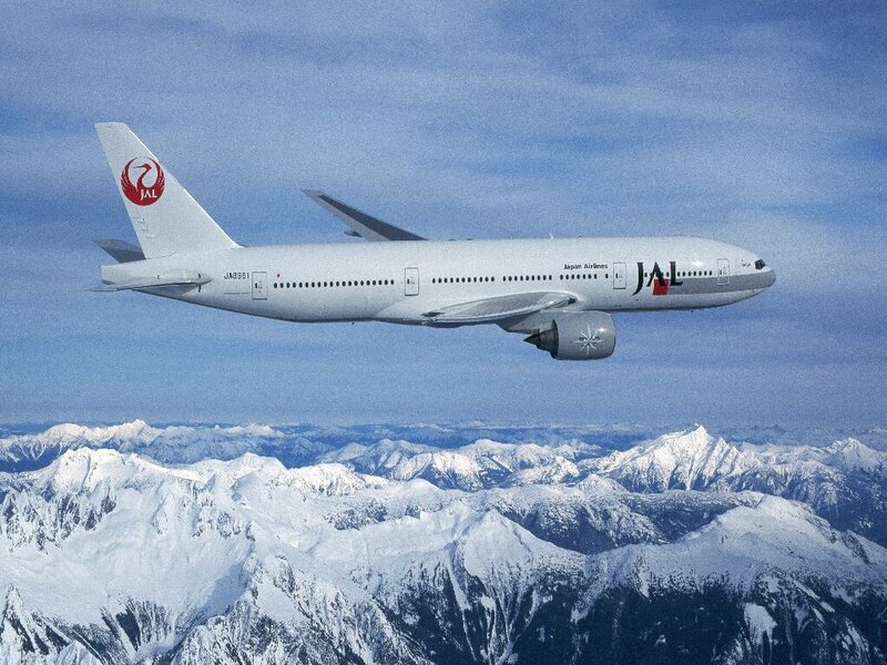 JAL airplane over snowy mountains