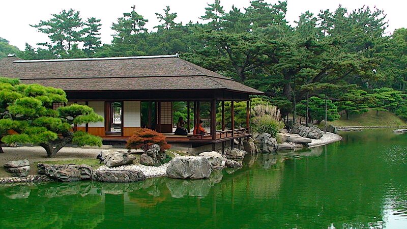 Japanese garden pavilion by pond