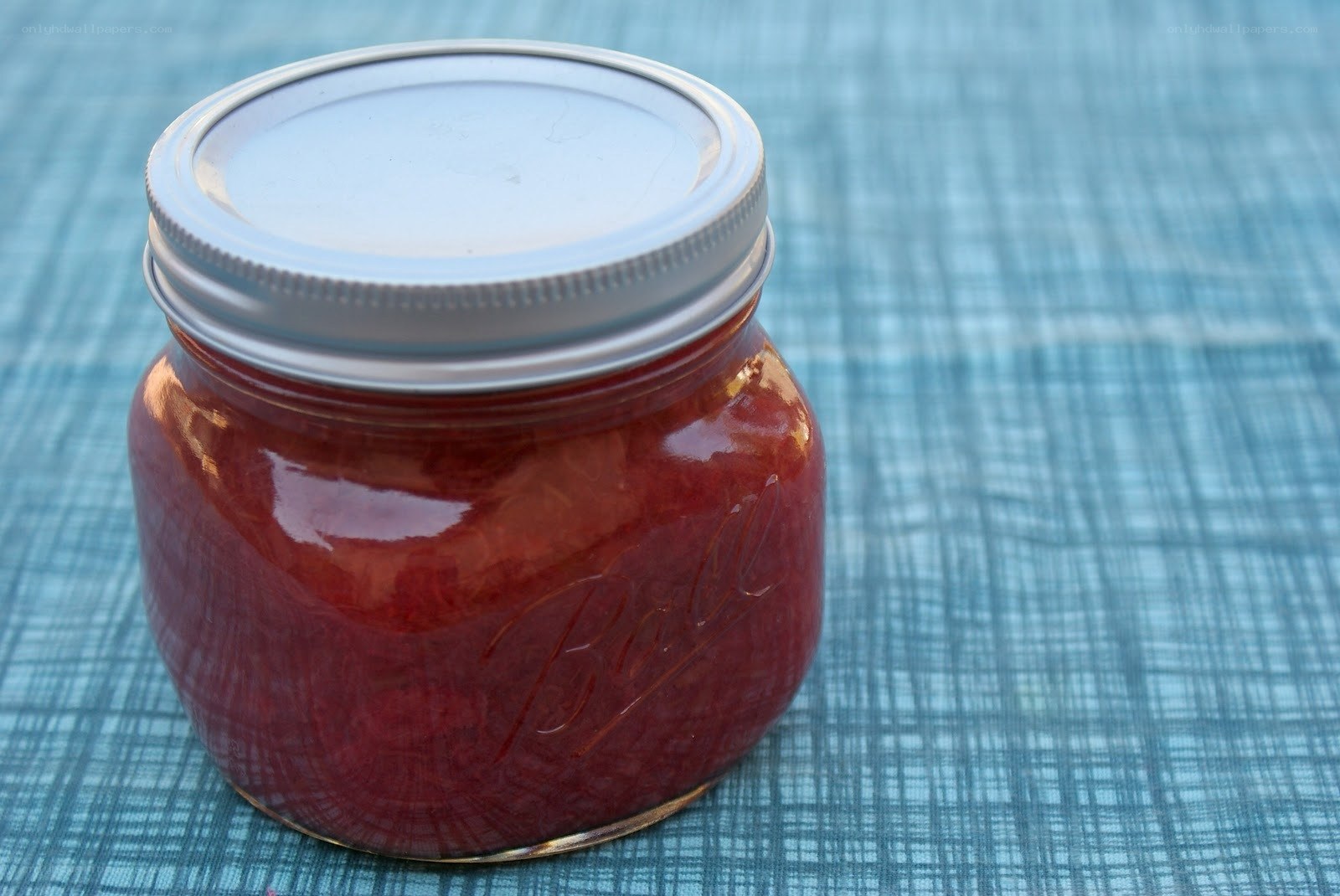 Jar of red jam on table