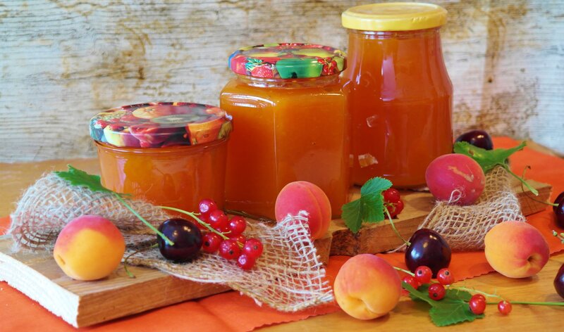 jars of fruit jam with fresh fruit