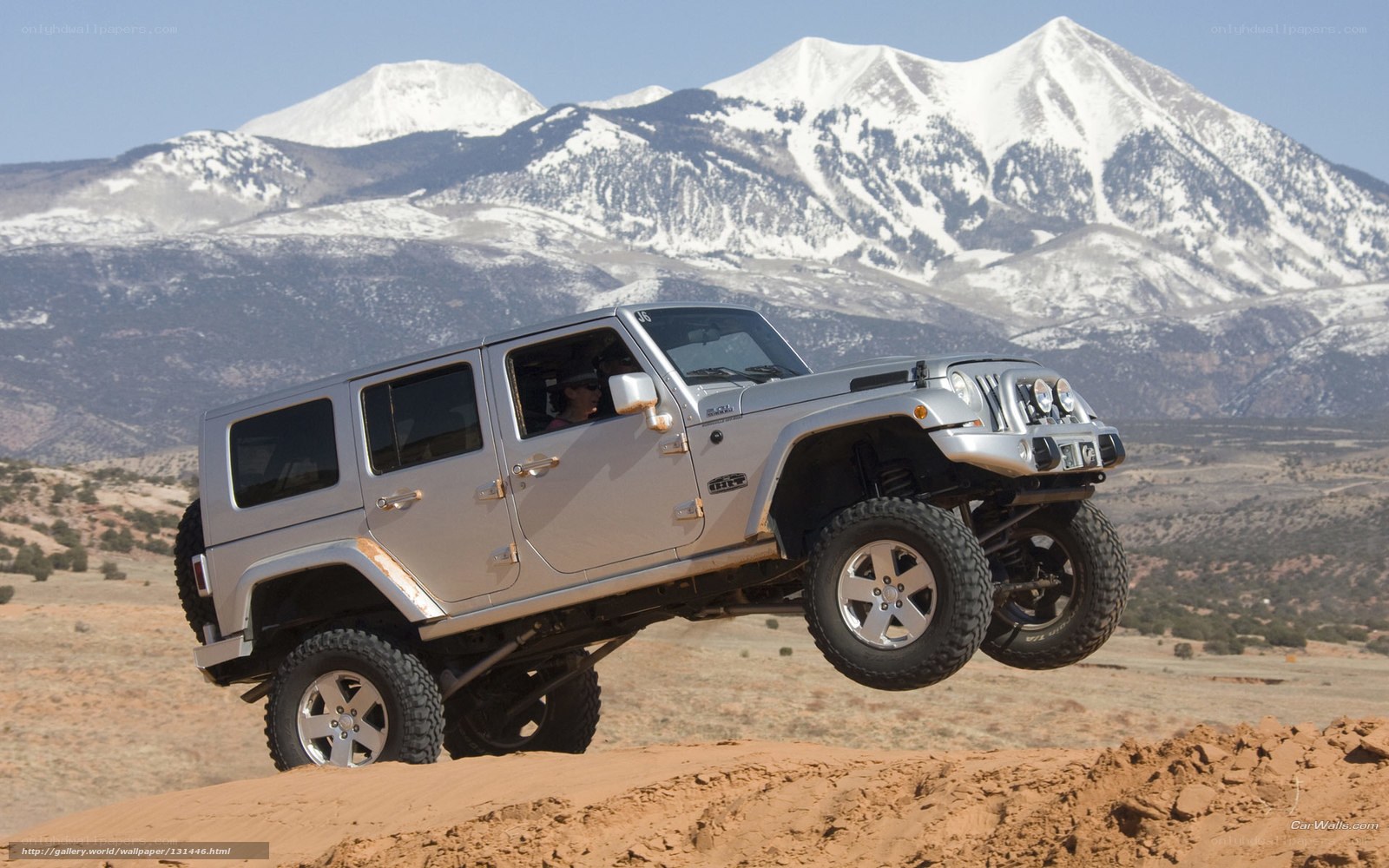 Jeep driving over desert hill
