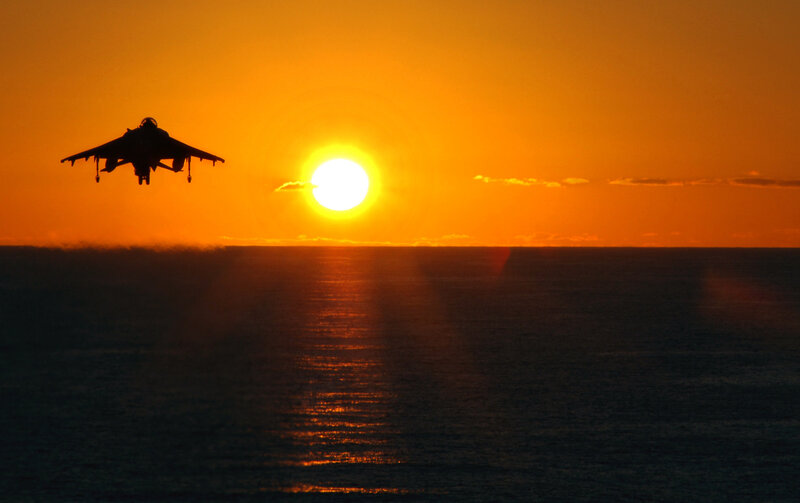 Jet aircraft at sunset over ocean