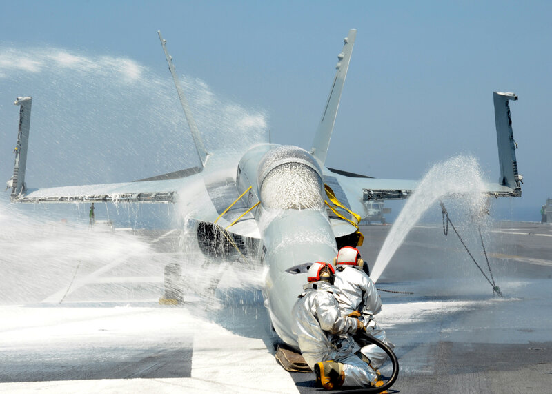 Jet aircraft being washed on carrier deck