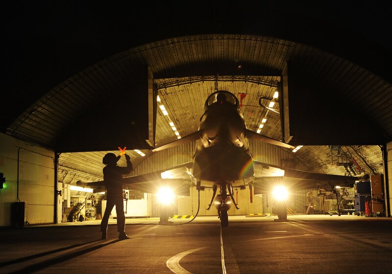 Jet aircraft in hangar at night
