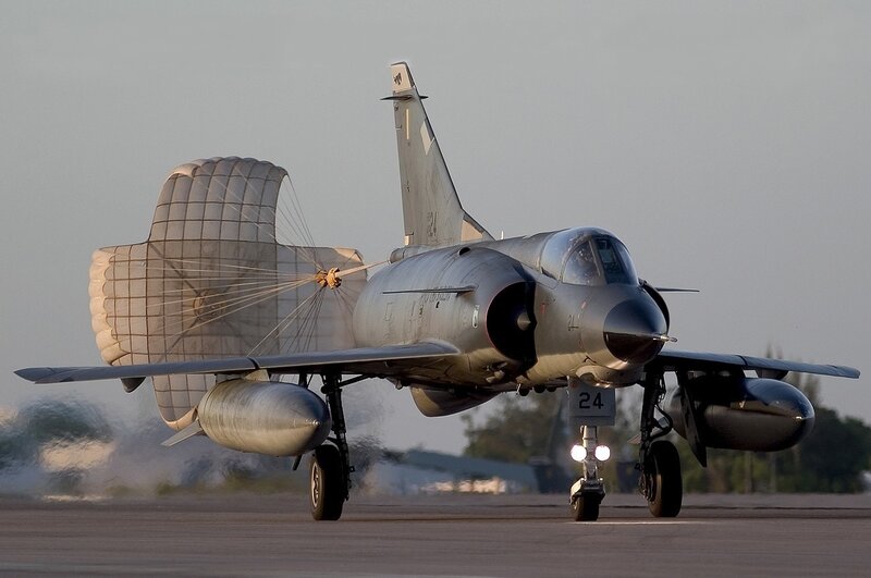 Jet aircraft with parachute on runway