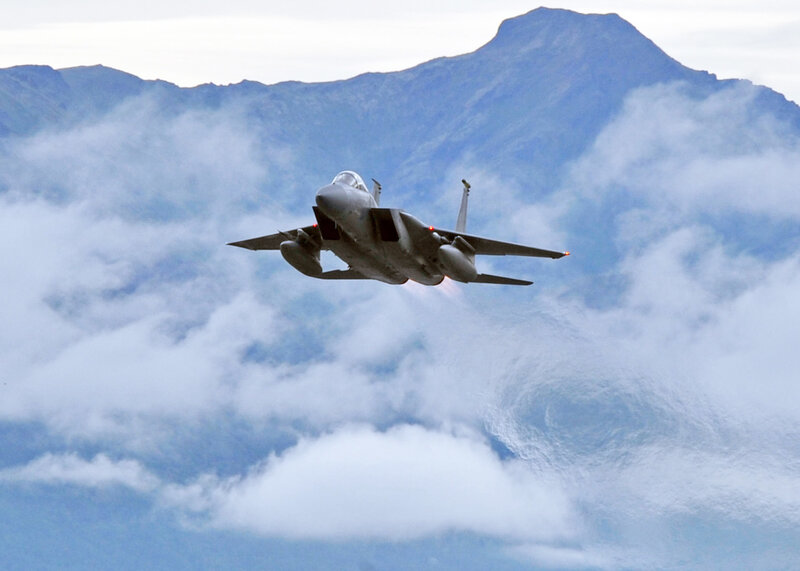 jet fighter flying over clouds