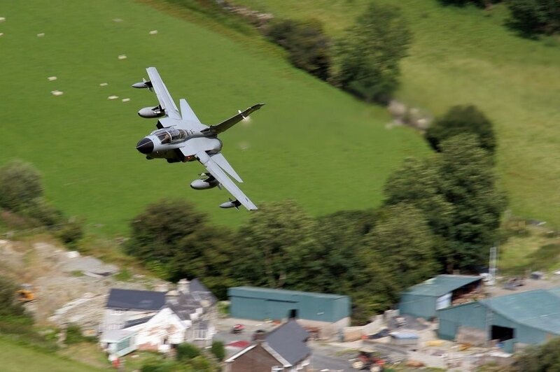 Jet fighter flying over countryside