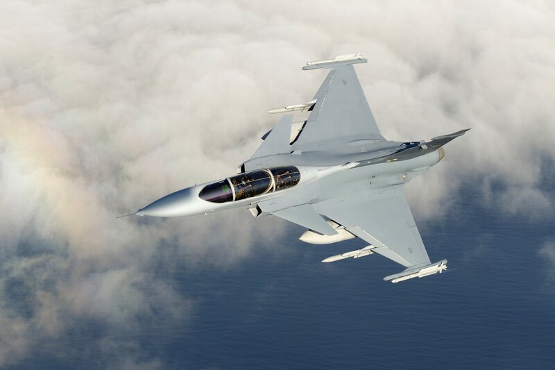 Jet fighter in flight above clouds