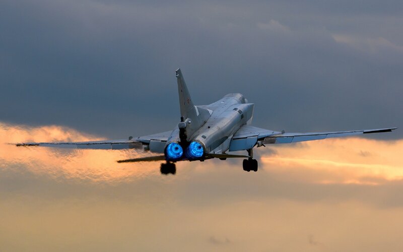 Jet fighter in flight at sunset