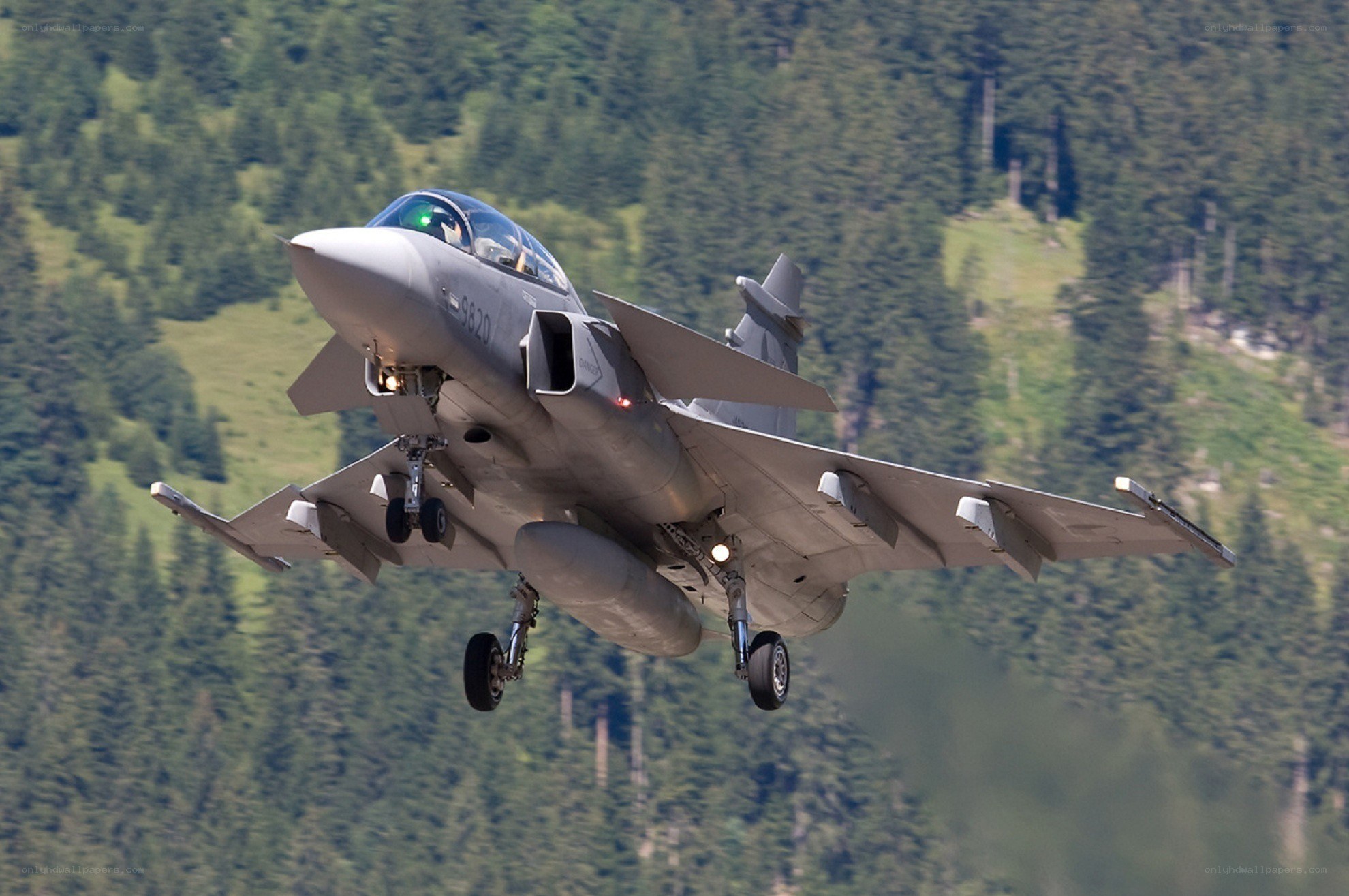 Jet fighter in flight over mountains
