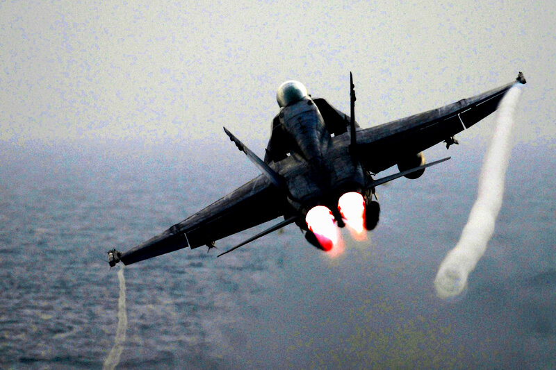 Jet fighter in flight over ocean
