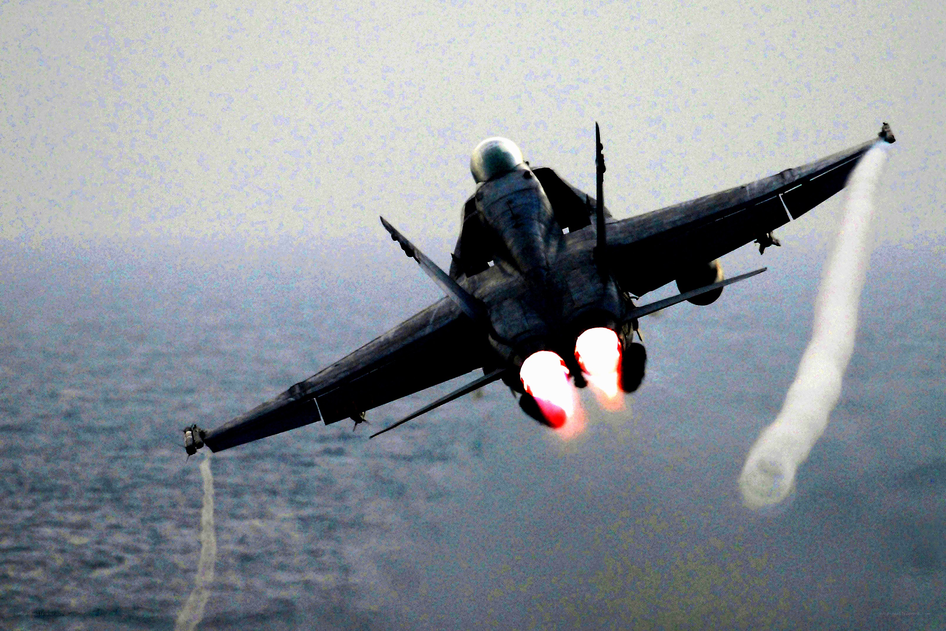 Jet fighter in flight over ocean