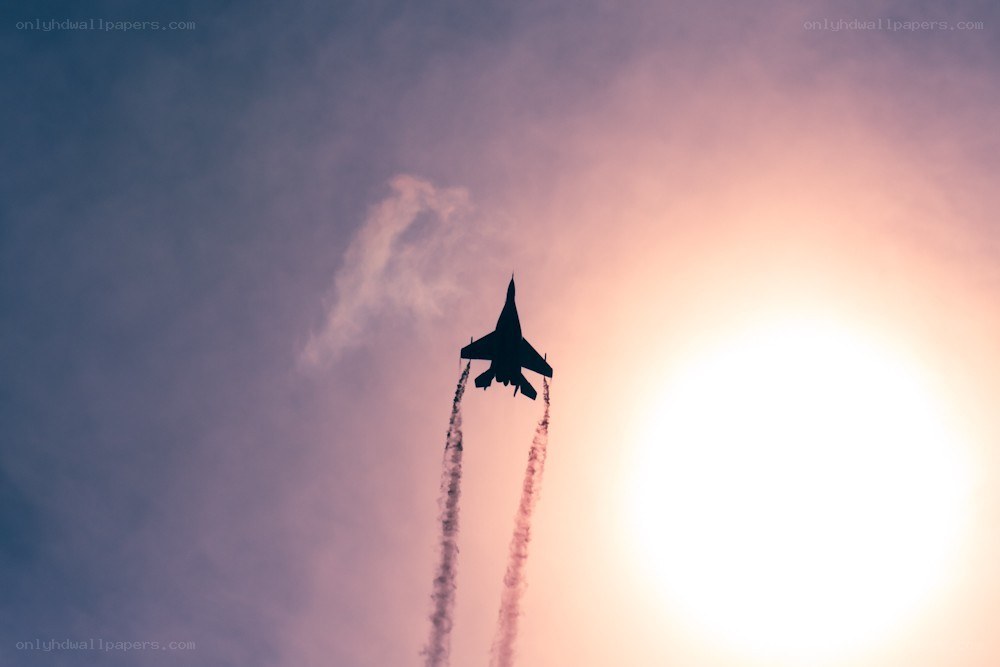 Jet fighter in sunset sky