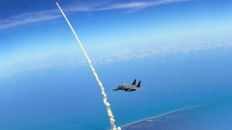 Jet fighter observes rocket launch