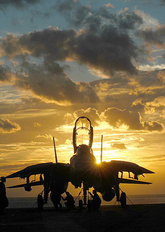 Jet fighter on aircraft carrier at sunset