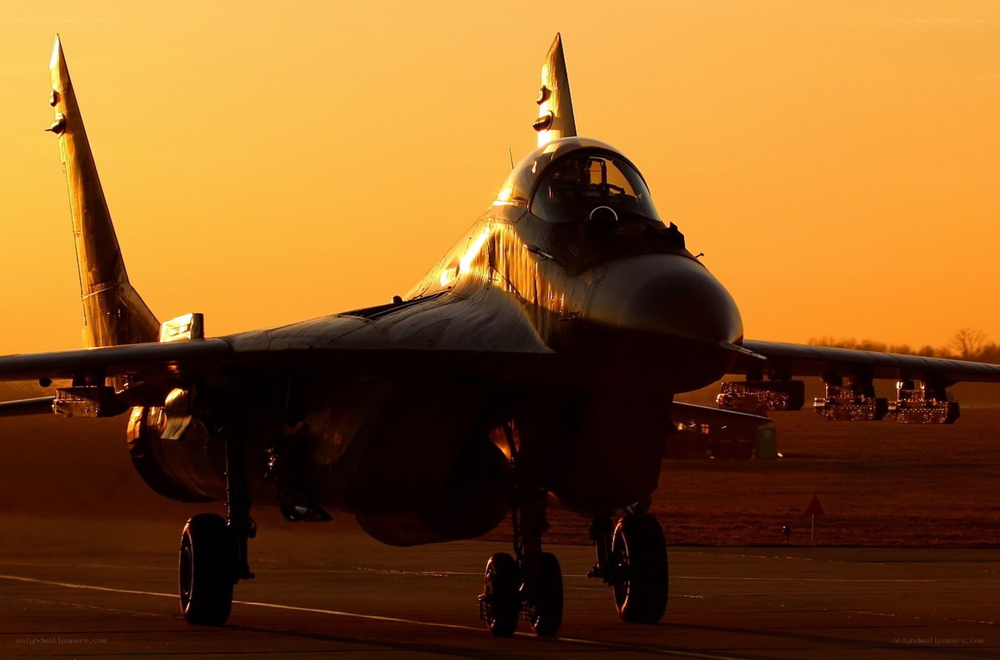 Jet fighter on runway at sunset