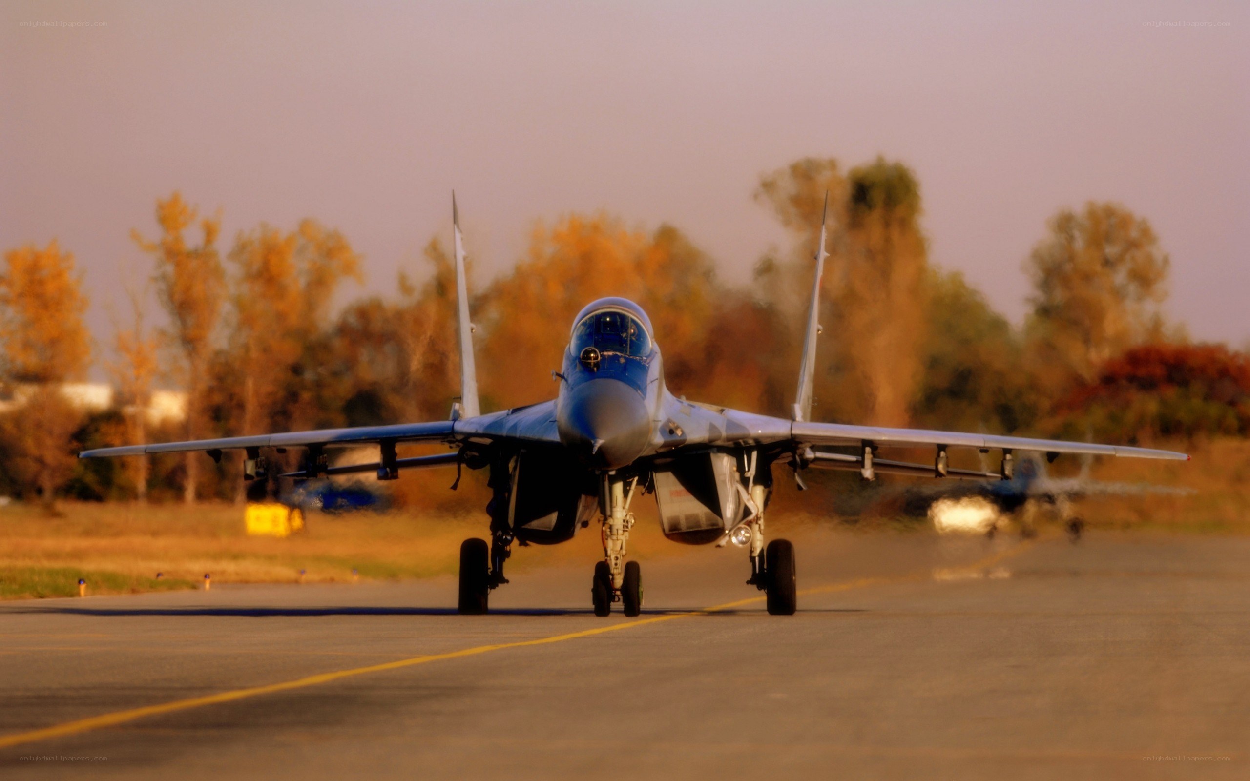 Jet fighter on runway at sunset